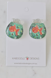 Pair of glitter resin goldfish bowl stud earrings on Kaboodle Designs card, front view