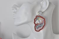 Close-up side profile of unicorn earring worn on ear showing holographic stud and pearl shaker detail