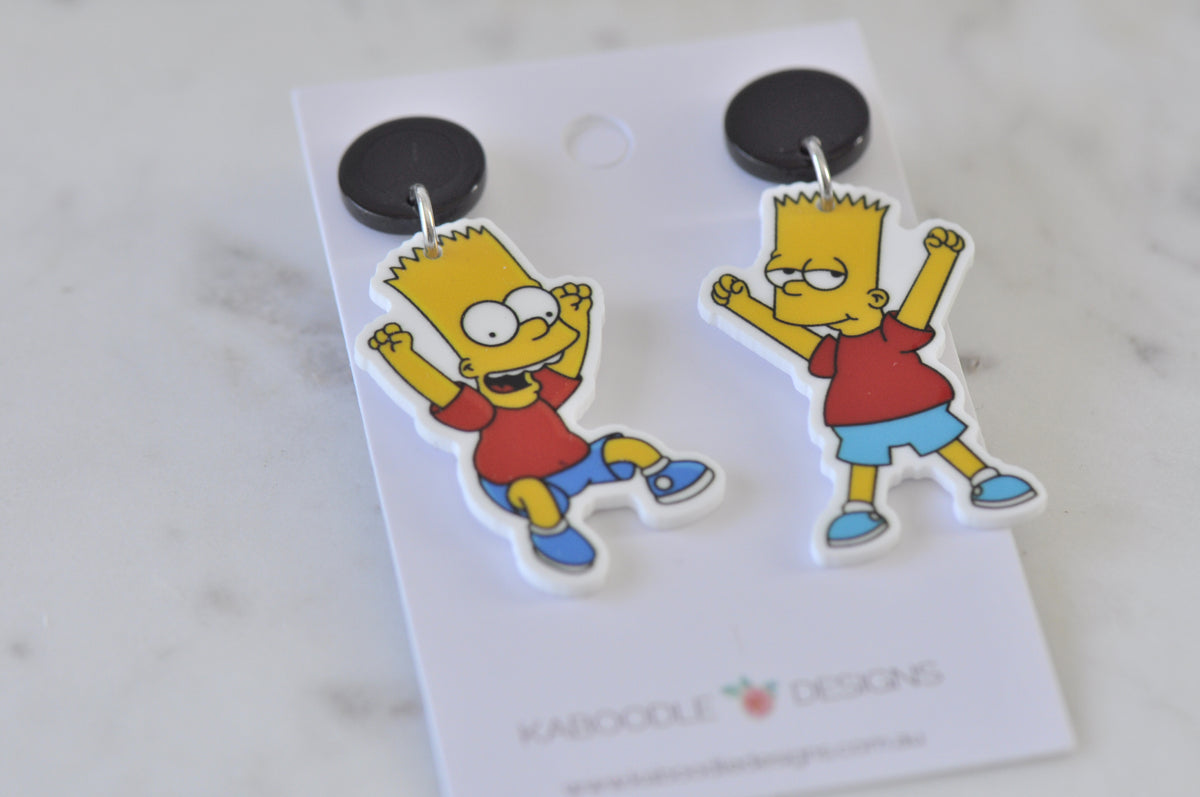 Close-up of Bart Simpson dangle earrings showing two different poses hanging from black studs