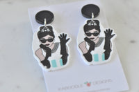 Overhead view of both drop earrings on Kaboodle Designs backing card showing full illustrated design and black stud tops