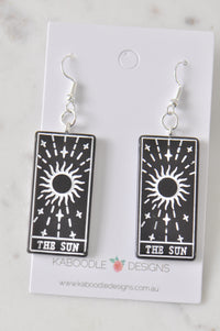 Pair of black resin The Sun tarot card drop earrings on Kaboodle Designs card