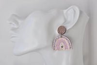 Close-up side view of leopard rainbow earring worn on a mannequin ear