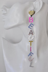Close-up of BEAUTIFUL letter earring on ear-shaped display, showing multicoloured glitter acrylic letters