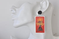 Close-up of Pocky earring worn on ear, showing red packet design and stick detail