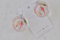 Both goldfish bowl earrings laid flat on card beside Kaboodle Designs branding