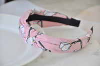 Close-up of pink floral headband showing knot detail and black underside