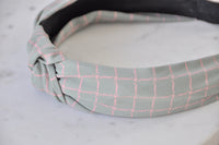 Close-up of headband knot showing checkered fabric texture and pink grid pattern