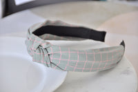 Side view of grey checkered headband showing knot detail and black underside