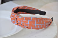 Close-up side view of knotted headband showing check pattern and black underside