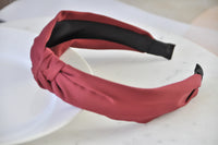 Side angle of burgundy knotted headband showing black underside and tapered ends