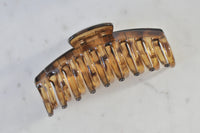Transparent brown acrylic claw clip viewed from above showing wide open teeth