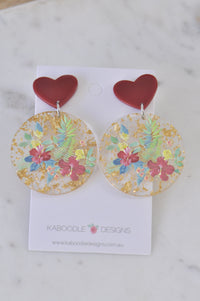 Pair of heart-top floral drop earrings with gold foil flecks on display card