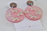 Close-up of pink carousel horse earrings side by side showing full detail