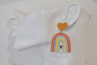 Close-up side view of one rainbow earring worn on a display ear