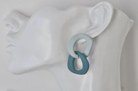 Close-up side view of teal and sage link earring on a display ear