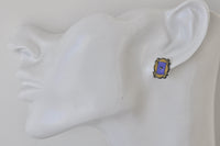 Close-up of yellow and purple frame stud earring worn on ear