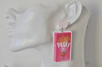 Close-up of single Pocky strawberry earring worn on ear, showing box design detail