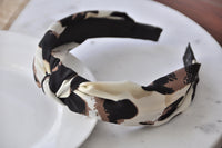 Close-up top view of animal print fabric headband showing the knotted centre detail