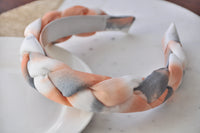 Peach, grey and white braided fabric headband shown from the front