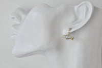 Saturn planet earring shown worn on ear model for scale