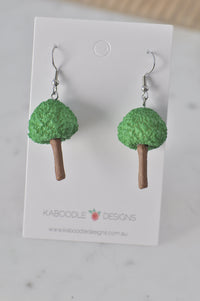 Pair of green textured resin tree earrings with brown trunks on Kaboodle Designs card