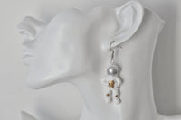 Astronaut earring with gold star detail shown on ear, side angle