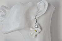 Close-up of astronaut earring with coloured badge worn on ear