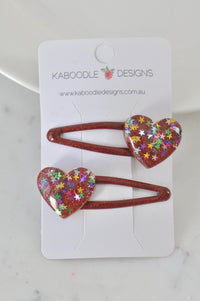 Two red glitter heart barrette clips on Kaboodle Designs branded card, close-up front view