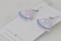 Lilac Saturn earrings laid on Kaboodle Designs card showing polka dot texture