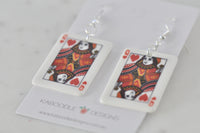 Angled view of two Queen of Hearts earrings resting on branded card
