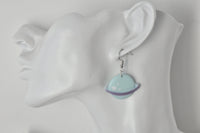Single mint Saturn earring shown worn on ear for scale