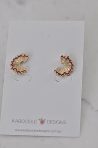Pair of gold-tone pencil shaving stud earrings with red enamel edge on Kaboodle Designs card