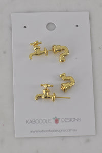 Gold-tone tap and pipe stud earrings on Kaboodle Designs card, front view