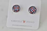Round stud earrings with navy background and red and white floral pattern, on Kaboodle card