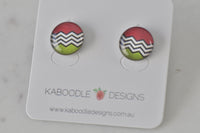 Round stud earrings on card with red, black-and-white chevron, and green artwork design