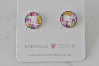 Round stud earrings with colour-block geometric artwork in pink, purple, yellow and teal, on Kaboodle Designs card