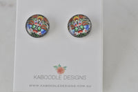 Pair of round stud earrings with colourful kaleidoscope artwork in red, blue, green and yellow on a card