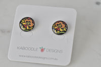 Round stud earrings on card featuring orange and yellow boho flower artwork on black background