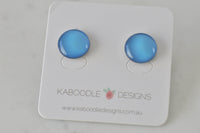 Round blue artwork stud earrings with glossy clear cover on Kaboodle Designs card