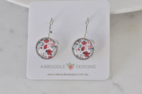 Round silver-tone leverback earrings with red and pink floral print, shown on Kaboodle Designs card