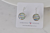Round silver-tone dangle earrings with blue, orange and green striped pattern on display card
