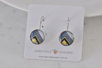 Round leverback earrings with black, yellow and blue art deco geometric print on card