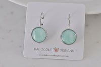 Pair of round watercolour turquoise leverback earrings on a Kaboodle Designs card