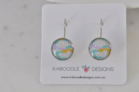Round polkadot watercolour leverback earrings on Kaboodle Designs card, showing aqua, lilac and mustard print with black dots