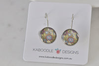 Round leverback earrings with yellow, pink and blue kaleidoscope pattern on Kaboodle Designs card
