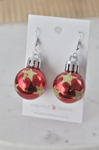 Pair of red bauble drop earrings with gold glitter stars on Kaboodle Designs card