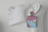 Close-up side view of geometric drop earring worn on a mannequin ear