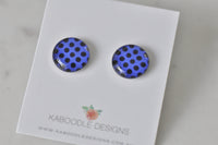 Round blue and black polka dot stud earrings displayed on a Kaboodle Designs card