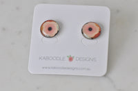 Round handmade poppy artwork stud earrings on Kaboodle Designs card, front view