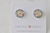 Round floral artwork stud earrings on Kaboodle Designs card, pink and yellow flowers under glossy dome